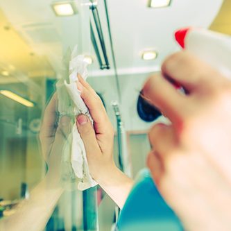 Office Windows Cleaning. Male Worker Cleaning Glass Walls in the Office Area. Cleaning Service.